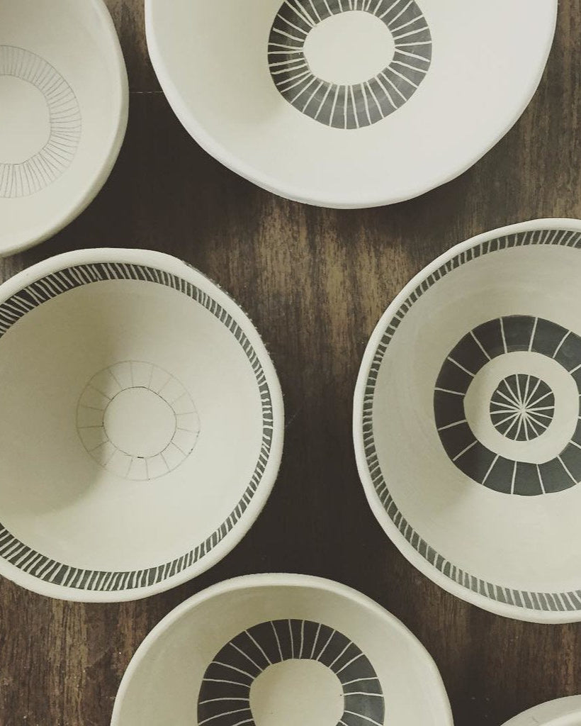 Set of ceramic bowls with geometric patterns on a wooden surface